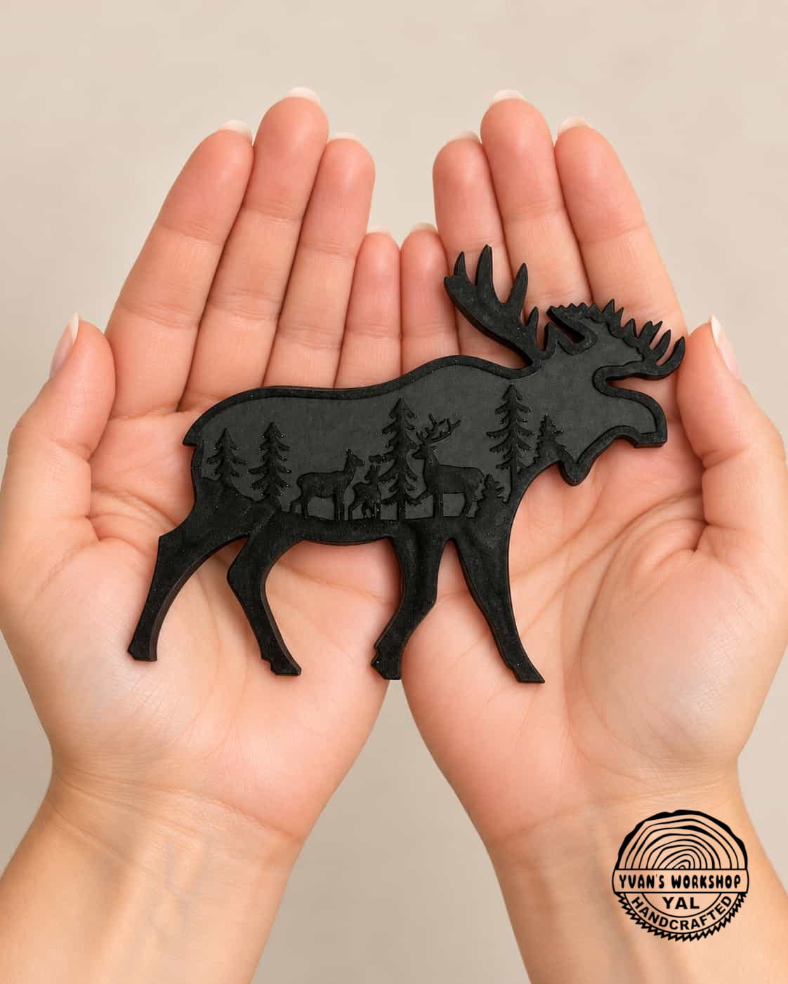 Black moose-shaped ornament with antlers and engraved evergreen woodland scene