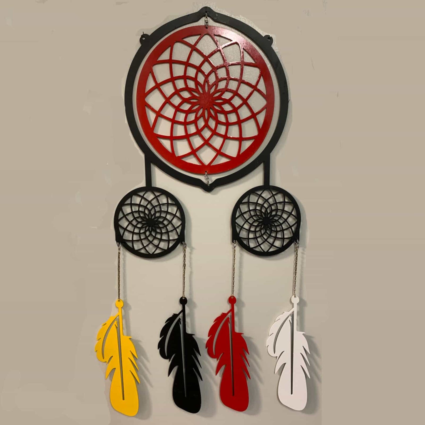 large metal dreamcatcher outdoor decor with rotating center web hanging from tree at lakeside cottage