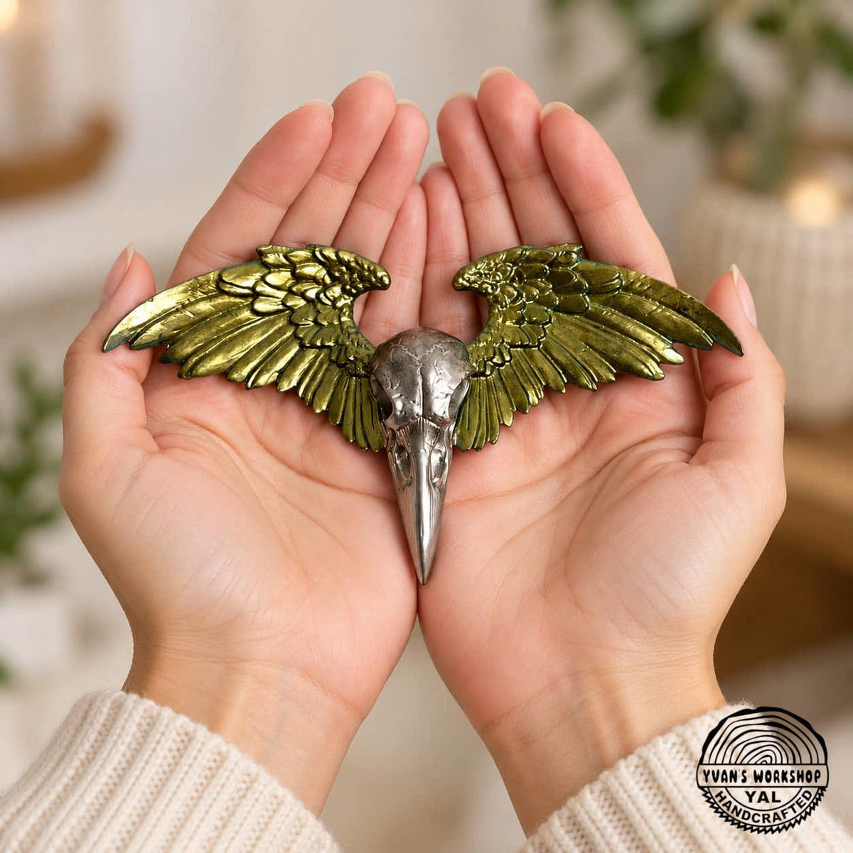 Silver raven skull with outstretched gold wings