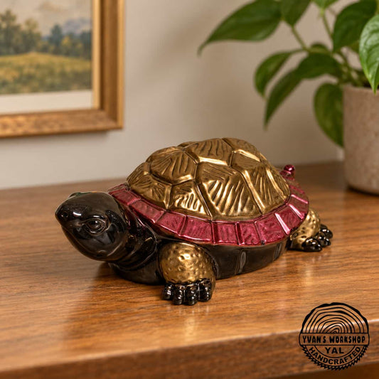 Hand-painted epoxy turtle decor in red & gold resting across two open hands to show its size.