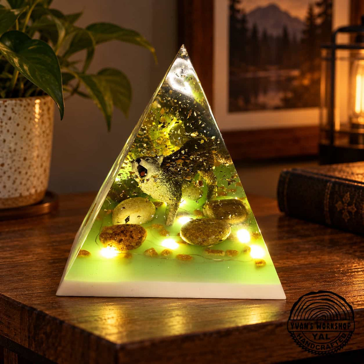 Illuminated resin pyramid with a wolf figure, stones and gold flecks