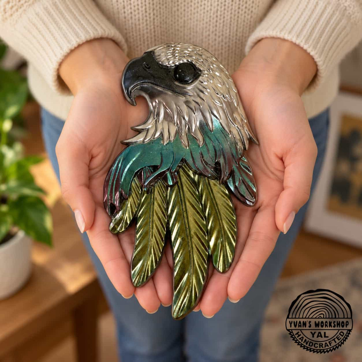 Chrome eagle head ornament with burgundy and teal middle feathers and gold lower feathers