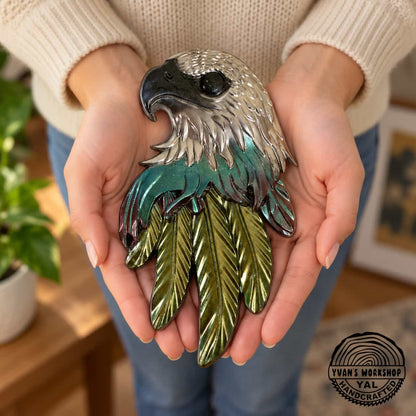 Chrome eagle head ornament with burgundy and teal middle feathers and gold lower feathers