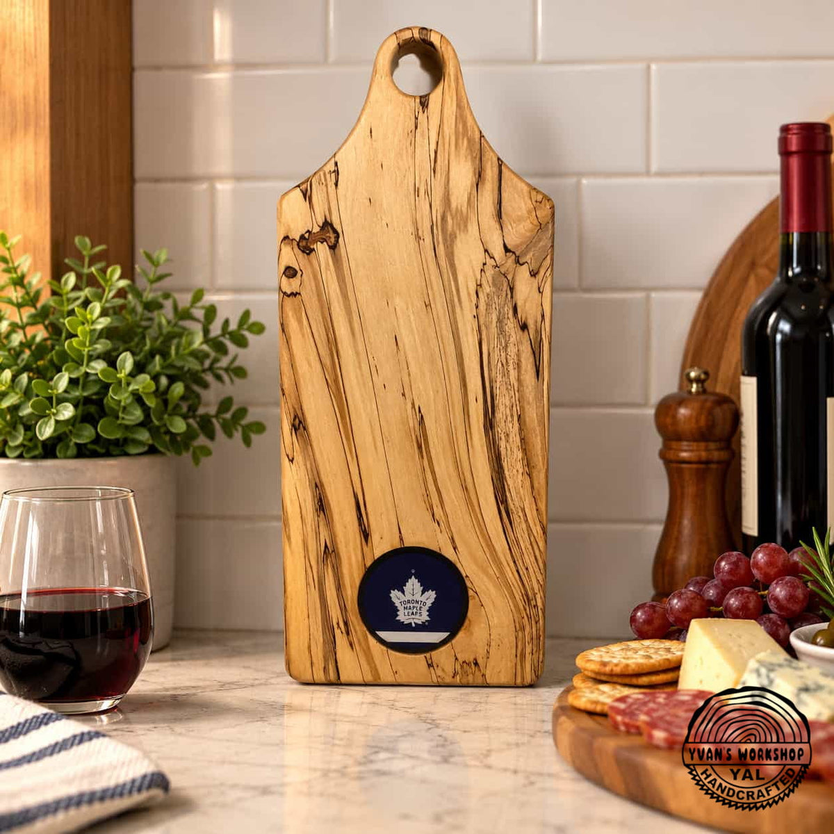 Spalted maple serving board with dark blue puck inset on a kitchen counter